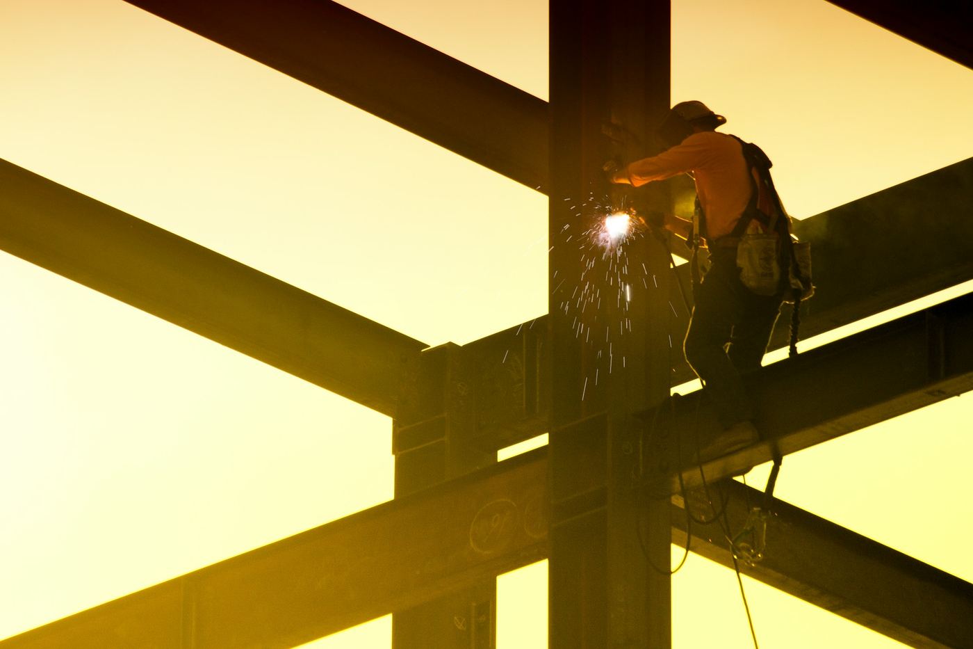 Welder working at height on structural steel beams