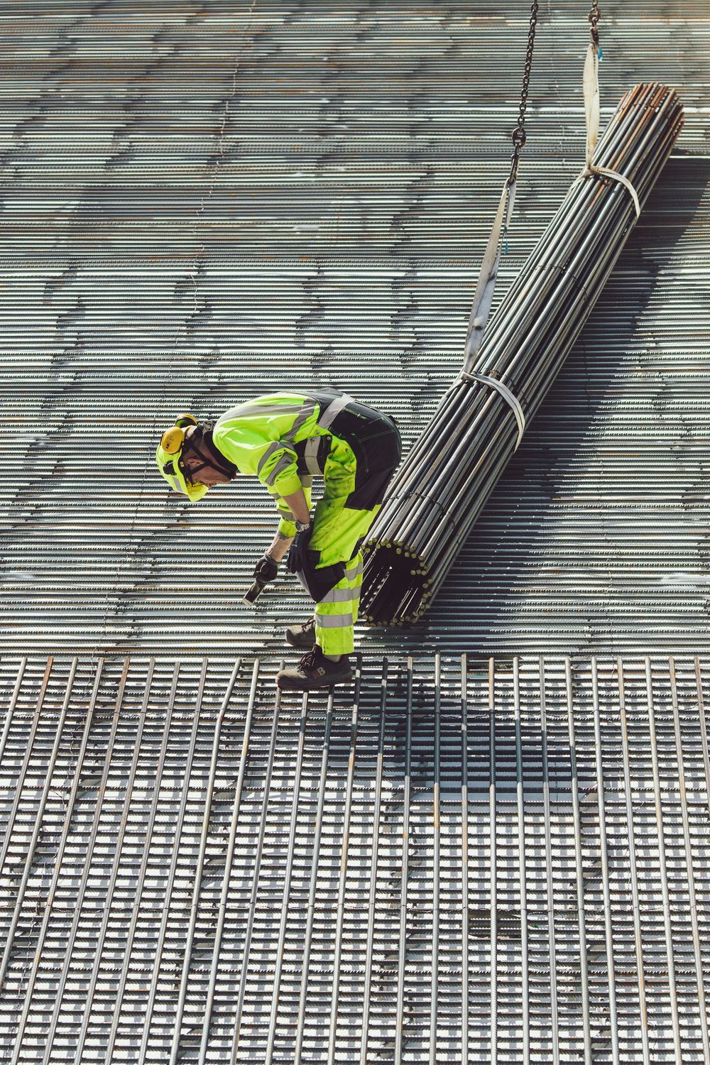 Construction worker in high-visibility clothing and hard hat on steel grating
